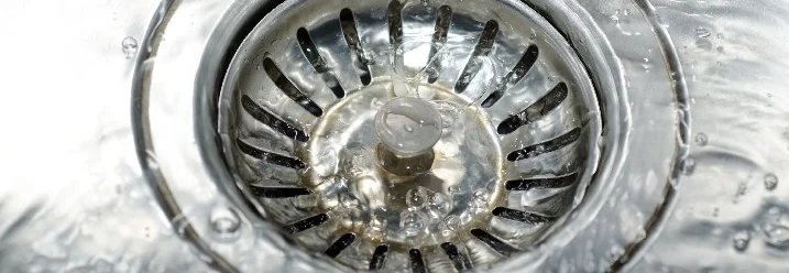 Wasser fließt in einen Abfluss.